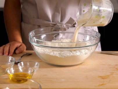 اضافه کردن خمیر مایه به آرد که در کاسه شیشه ای است
